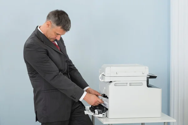 Geschäftsmann entfernt Papier, das klebt — Stockfoto