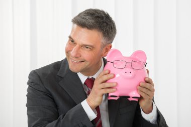 Businessman Holding Piggybank clipart