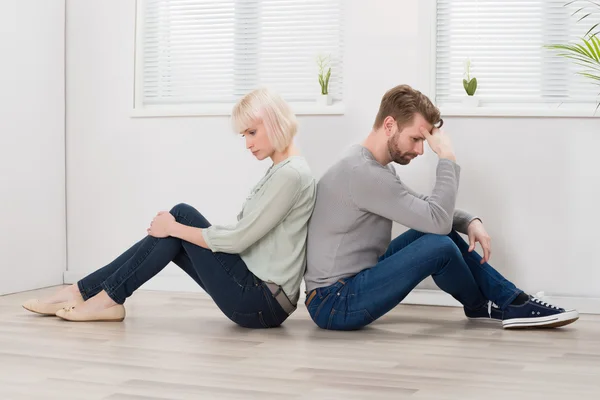 Pareja sentada espalda con espalda — Foto de Stock