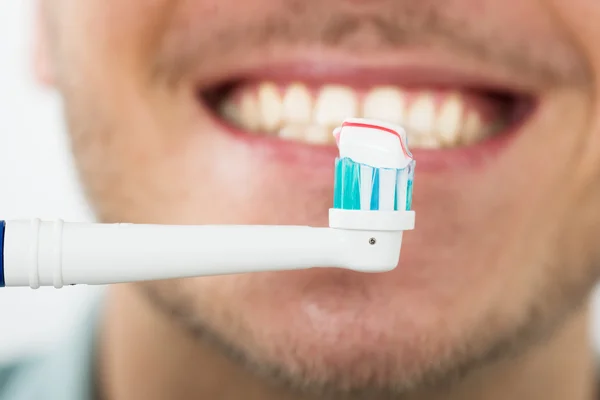 Homem com escova de dentes elétrica — Fotografia de Stock