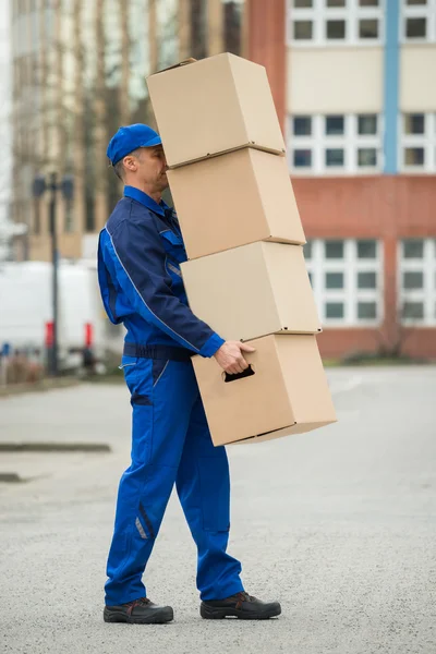 Homem de entrega com pilha de caixas — Fotografia de Stock