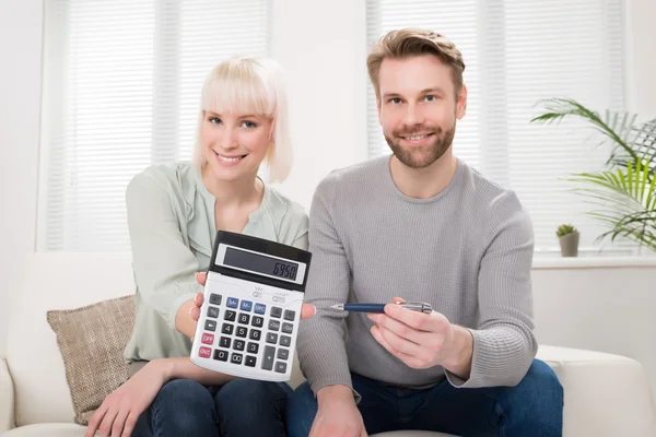 Paar zeigt Taschenrechner — Stockfoto