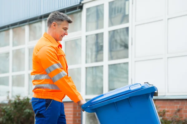 Мужчина-рабочий с мусорным баком — стоковое фото