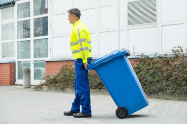 Erkek işçi çöp kovası ile yürüyüş 