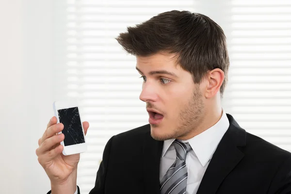 Бизнесмен со сломанным мобильным телефоном — стоковое фото