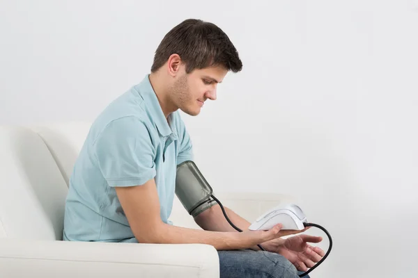 Uomo che controlla la pressione sanguigna — Foto Stock