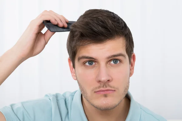 Mannen kammar sitt hår — Stockfoto