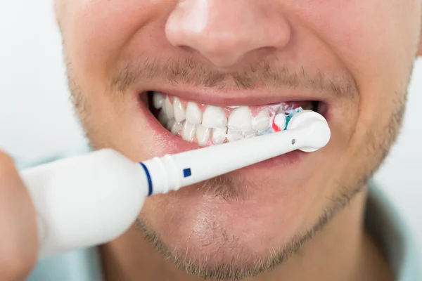 Hombre con cepillo de dientes eléctrico — Foto de Stock