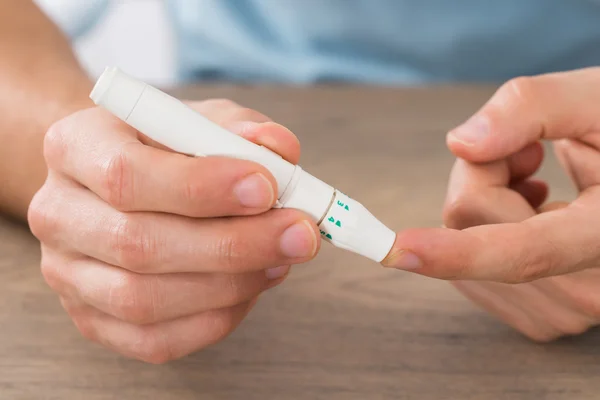 Homem verificando o nível de açúcar no sangue — Fotografia de Stock