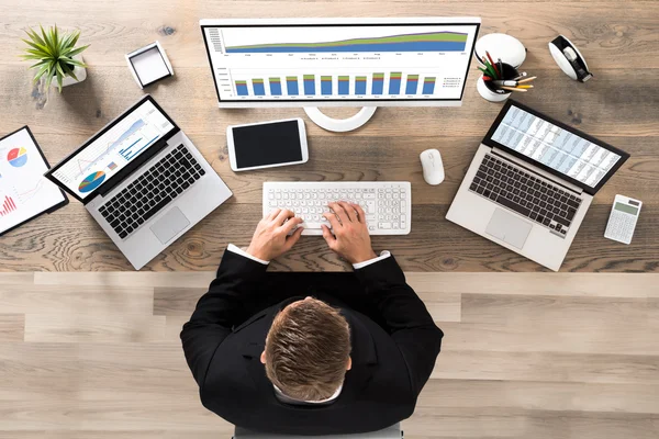 Zakenman analyseren van financiële grafieken in office — Stockfoto