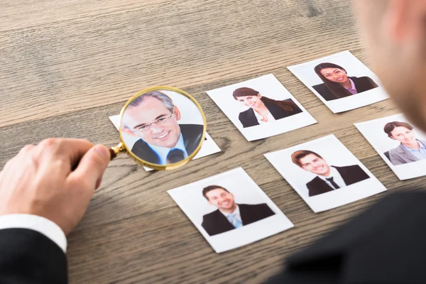 Empresário Visualizando candidatos através de lupa — Fotografia de Stock