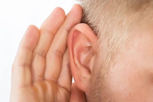 Pessoa que tenta ouvir com a mão sobre o ouvido — Fotografia de Stock