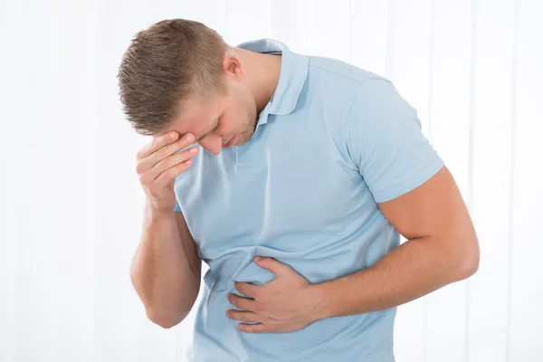 Mladý muž trpí bolest žaludku — Stock fotografie