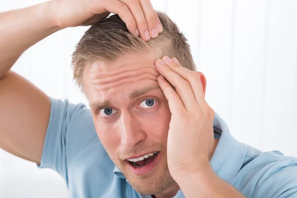 Homem examinando seu cabelo — Fotografia de Stock