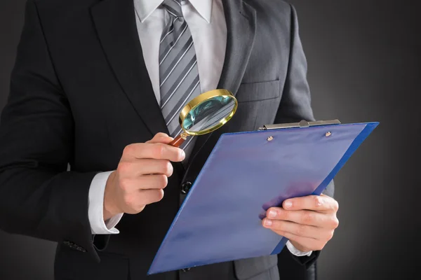Businessman Examining Document On Clipboard — Stock Photo, Image