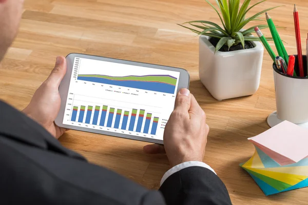 Бизнесмен смотрит на график на цифровой планшет — стоковое фото