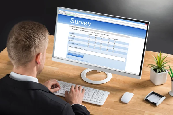 İşadamı bilgisayarda online anket formu doldurma — Stok fotoğraf
