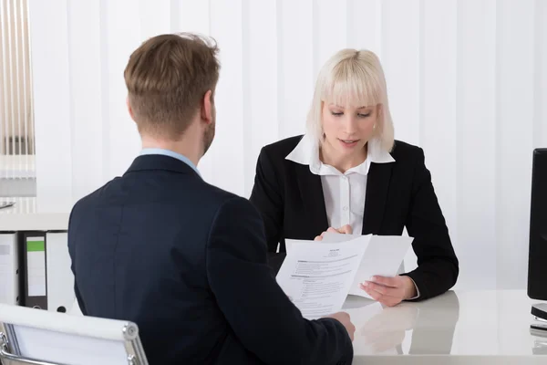 Mujer de negocios discutiendo sobre reanudar con candidato masculino — Foto de Stock