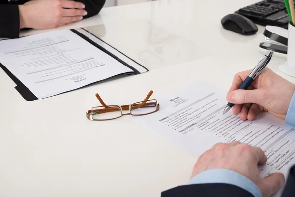 Businessperson Holding Pen Over Resume — Stock Photo, Image