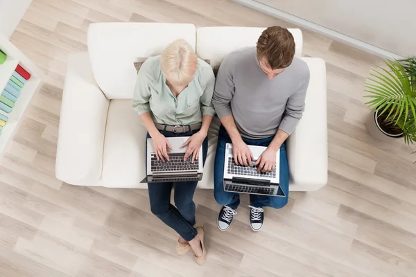 Paar sitzt mit Laptop auf Sofa — Stockfoto