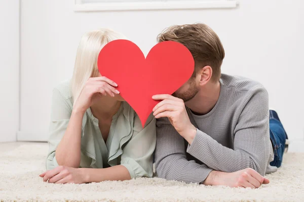 Casal beijando atrás da forma do coração — Fotografia de Stock