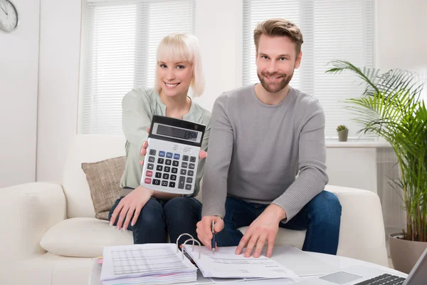 Casal feliz mostrando calculadora Imagem De Stock