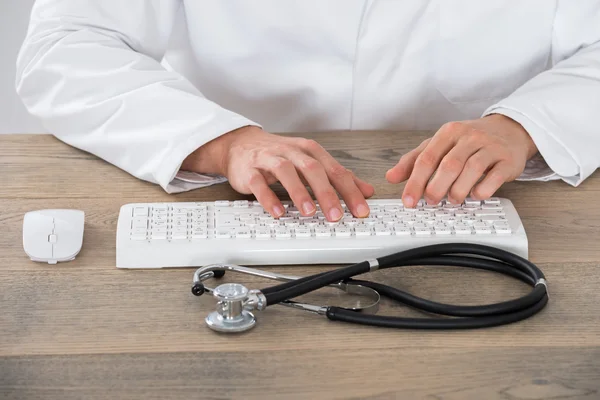 Doutor digitando no teclado do computador — Fotografia de Stock