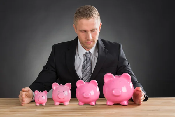Молодой бизнесмен со свиньями — стоковое фото
