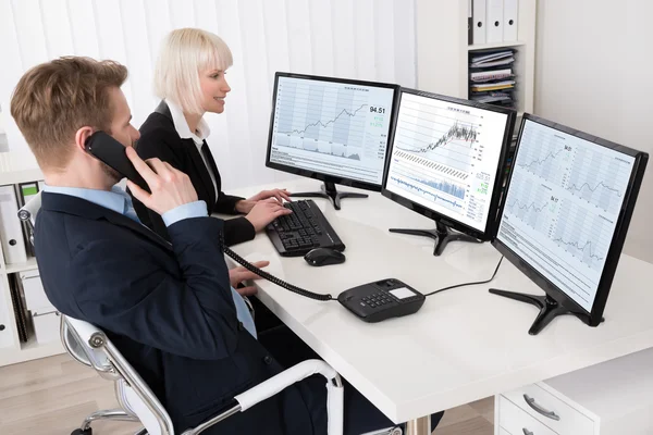 Ondernemers analyseren voorraadgrafieken — Stockfoto