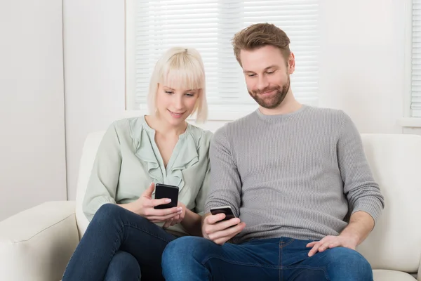 Pareja usando teléfonos celulares —  Fotos de Stock