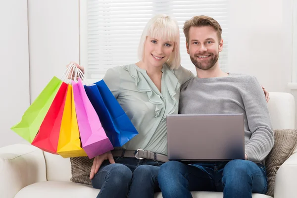 Casal segurando sacos de compras — Fotografia de Stock