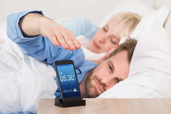 Man Snoozing Alarm Clock