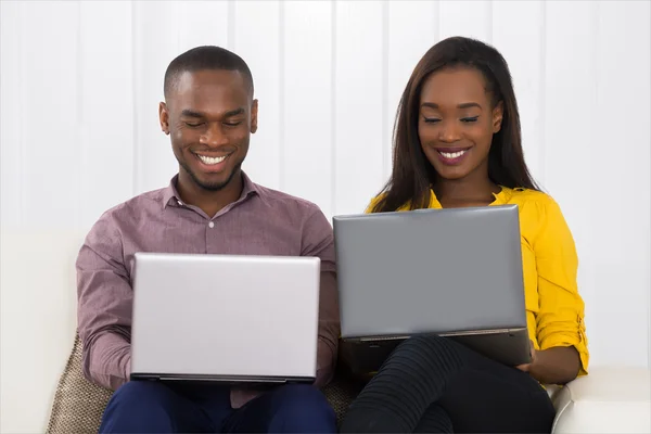 Pareja usando computadoras portátiles — Foto de Stock