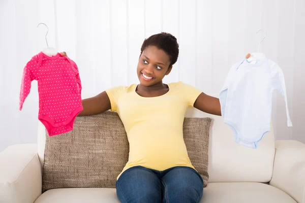 Pregnant Woman Holding Baby Clothes — Stock Photo, Image