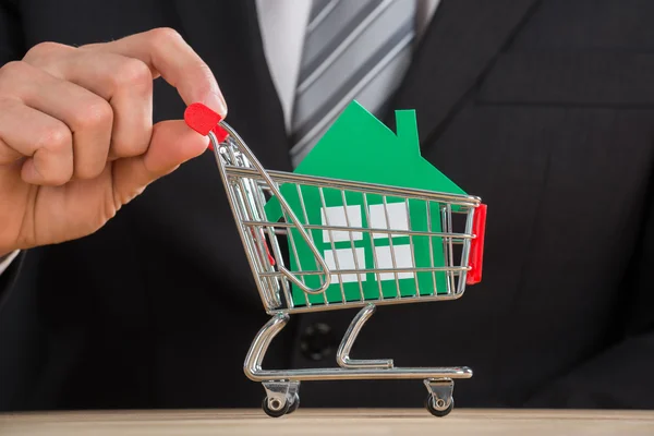 Empresário segurando carrinho de compras — Fotografia de Stock