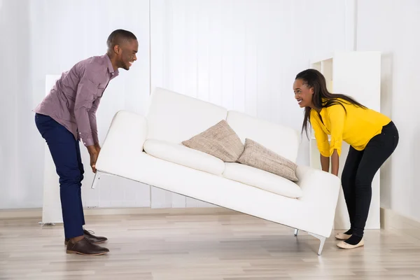 Couple Placing Sofa In Living Room — Stock Photo, Image