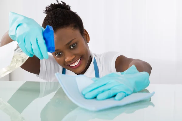 Gelukkig vrouwelijke Janitor schoonmaken Desk — Stockfoto