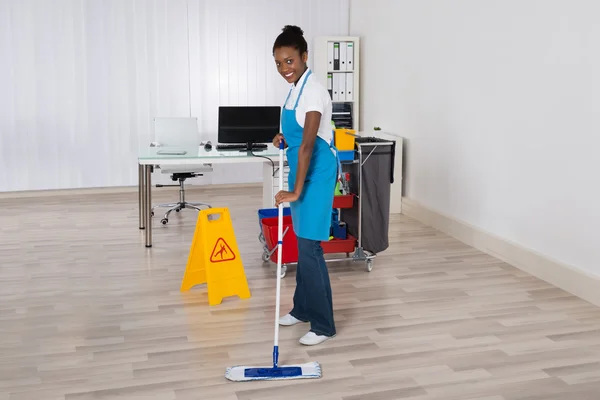 Kvinnliga vaktmästaren Mopping golv — Stockfoto