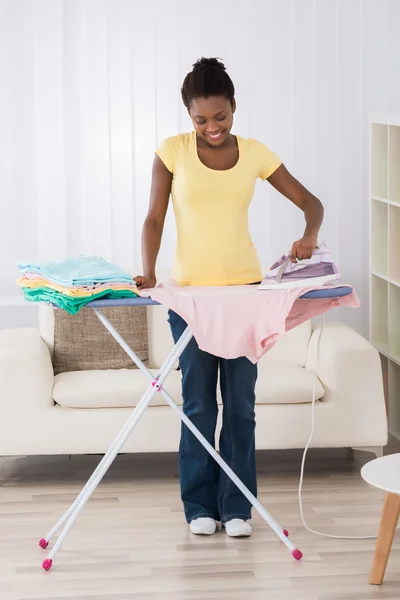 Ropa de planchar mujer en tabla de planchar — Foto de Stock