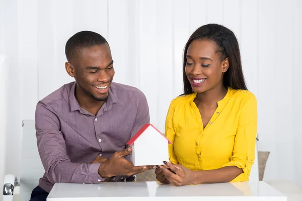 Jovem casal segurando modelo casa — Fotografia de Stock