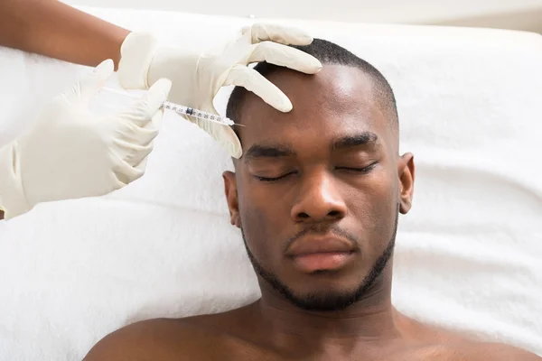 Persona inyectando jeringa en la cara — Foto de Stock