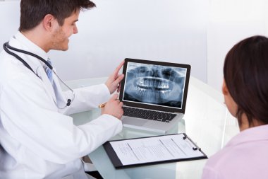 Doktor gösteren diş röntgen hastaya