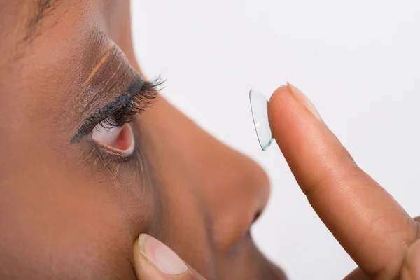 Jonge vrouw dragen van contactlenzen — Stockfoto