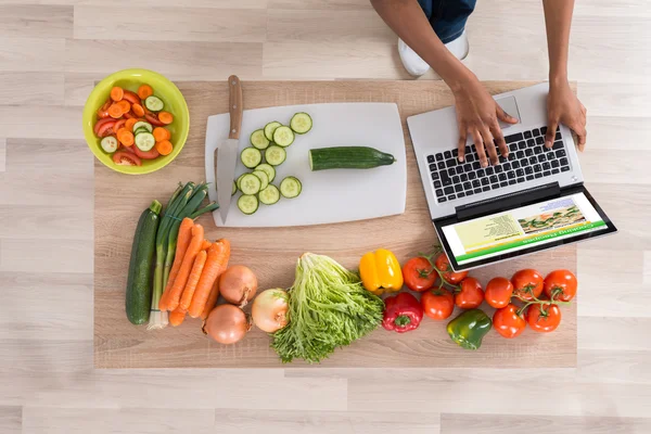 Mujer mirando receta en el ordenador portátil — Foto de Stock