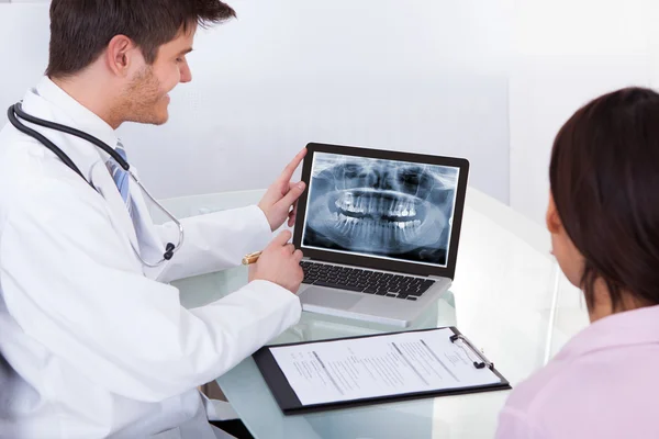 Doctor mostrando los dientes de rayos X al paciente —  Fotos de Stock