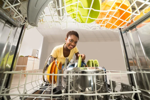 Mulher removendo placas de máquina de lavar louça — Fotografia de Stock