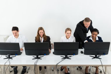 Businessman Helping His Colleagues In Office clipart