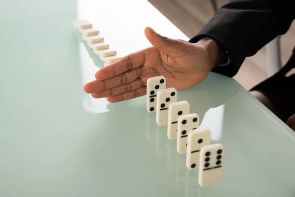 Empresaria mano detener dominó de caer — Foto de Stock