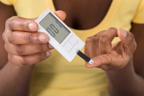 Mulher usando Glucometer — Fotografia de Stock