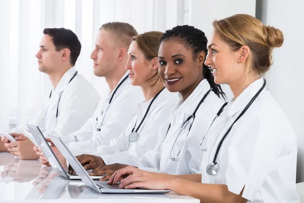 Artsen gebruik van laptop aan balie — Stockfoto